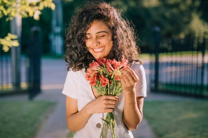 Smiling woman relaxing outdoors, representing the natural and authentic conversations people look for on video calling apps
